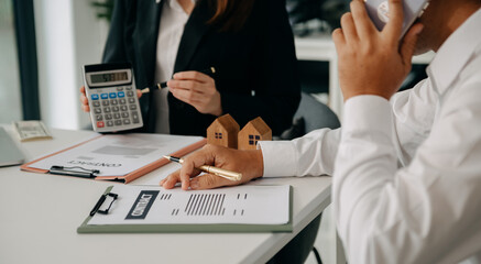 balancing the property sector The real estate agent is explaining the house style to see the house design and the purchase agreement.
