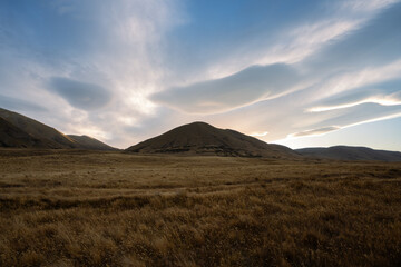 Obraz premium New Zealand landscape of clouds and mountains at sunset