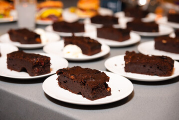 Rich Chocolate Brownies Served with Fresh Berries. Plates of dense and fudgy chocolate brownies accompanied by a dollop of whipped cream, ready for dessert service.