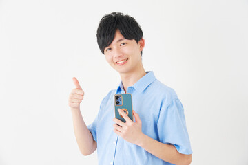 スマートフォンを持ってグッドサインをする男性　白背景