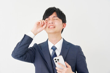 スマートフォンを持って泣くビジネスマン　白背景