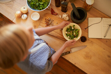 Woman, hands and chop salad with knife, wellness and health in a home from above. Vegan, wood board...