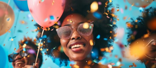 Young African woman with afro hairstyle celebrating birthday with friends. - obrazy, fototapety, plakaty