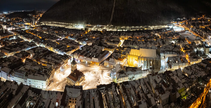 Aerial panoramic landscape photo with Brasov city. Brasov during a winter night, aerial view to its main landmarks of this city from Transylvania, Romania.