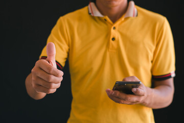 Close-up of a man using a cell phone and giving a thumbs up. Awesome.