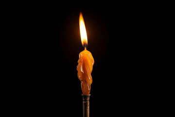 candle orange color burning molten, with streaks of paraffin on dark background