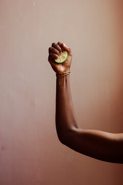 A hand holding a half-cut lemon