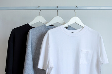 Collection of basic colors plain t-shirts mockup hanging on displayed of rack clothes