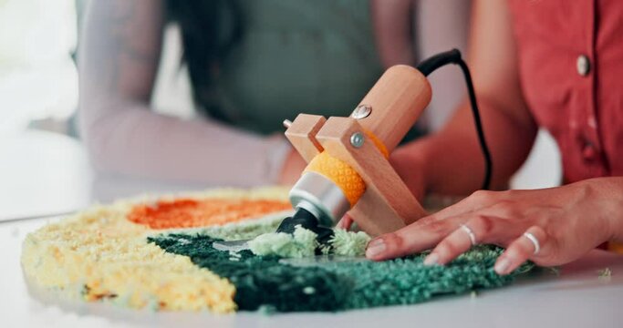 Hands, team or tufting with rug carver, design or shave textile together at table. Carpet, trimmer or closeup of professional with fabric, tools or electric machine to craft in manufacturing workshop