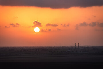 Beautiful, red, sunset sky over the Egyptian coast. View from cargo ship sailing through Suez Canal.
