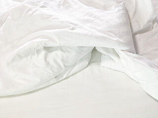 Unmade bed; wrinkled pillowcases, bed sheet and duvet