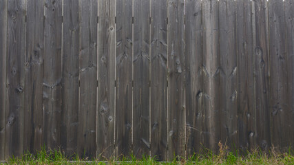 brown planks wooden background of fence wall of vertical wood boards on a horizontal facade with floor grass - Powered by Adobe