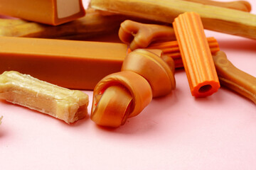 Dog chew bone and sticks on pink background