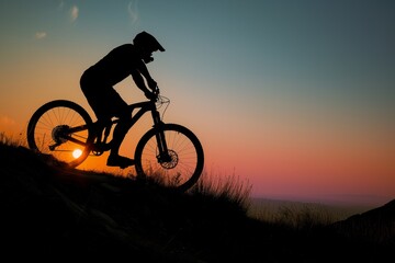 Obraz premium mountain biker silhouetted against sunset while climbing trail