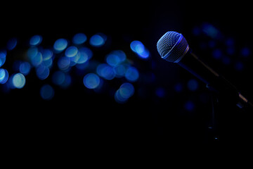 Live music background with microphone and stage blue lights bokeh effect