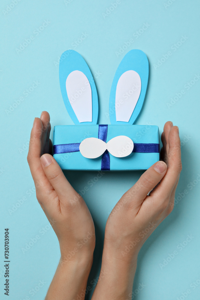 Wall mural blue gift box with bunny ears on a blue background