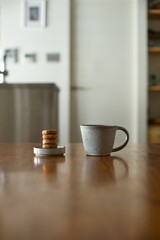 縦に積んだおやつのクッキーとマグカップの紅茶