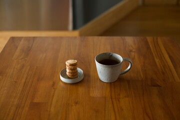 縦に積んだおやつのクッキーとマグカップの紅茶
