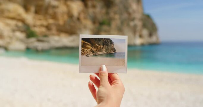 Hand, polaroid and beach for photography, vacation and memories for travel scrapbook. Female tourist, ocean background and sea for holiday, experience and images of Italy, nostalgia and summer