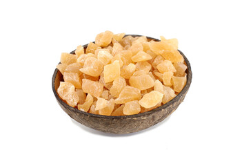 Dehydrated ginger cubes in a coconut shell. White background.