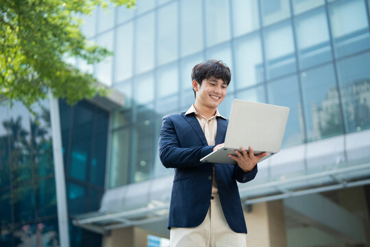Portrait of young Asian businessman outside