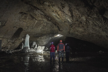 Adventurous Exploration of a Dark and Dangerous Cave with Icicles and a Rushing River