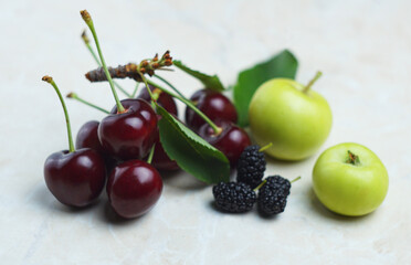 Red cherries and fruits on white marble