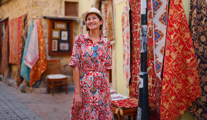 female summer travel to Antalya, Turkey. young asian woman in red dress walk old town Kalechi , female tourist traveler discover interesting places and popular tourist attraction, look on capret