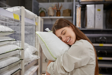 Happy satisfied woman customer finding best pillow for bedroom at store