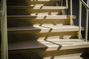 staircase with handrails casting shadows on steps