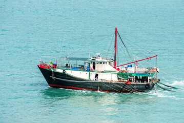 Naklejka premium Fishing boat sailing through calm waters near Vietnamese sea coast.