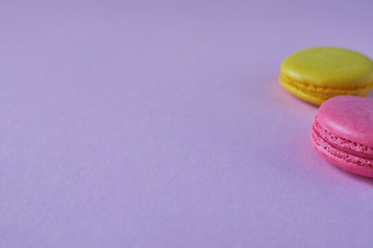 Colorful macaroon cookies on a purple background. Copy space.