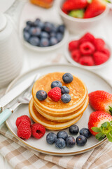 Homemade classic american pancakes with blueberries, raspberries and strawberries.