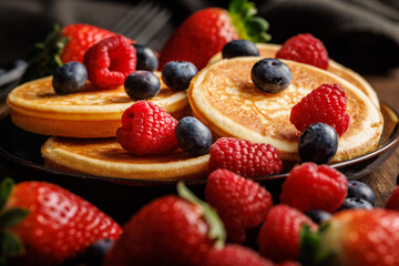 Homemade classic american pancakes with blueberries, raspberries and strawberries.