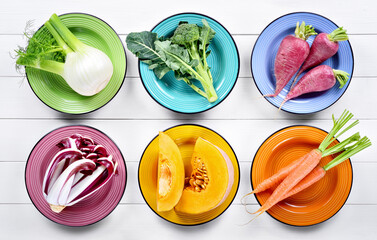 Colorful vegetables collection: fennel, broccoli, radishes, late red radicchio from Treviso, pumpkin and carrots on white wooden background, flat lay.