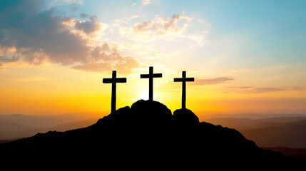 Silhouette of three crosses on a rock with sunset in the background. Easter concept.