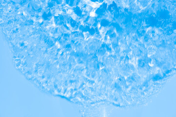 Water surface. Bluewater waves on the surface ripples blurred. Defocus blurred transparent blue colored clear calm water surface texture with splash and bubbles. Water waves with shining pattern.