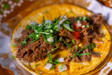 close up shot of birria taco with red sauce. Mexican food