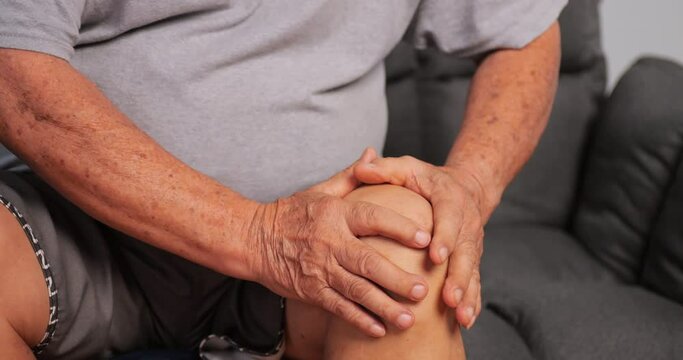 An elderly man suffering from osteoarthritis. Old man felt pain in his knee as he sat down.