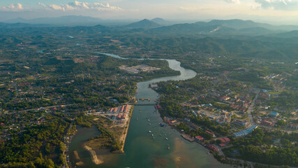 A landscape drone shot of a rural village at sunset with river in the middle of the picture