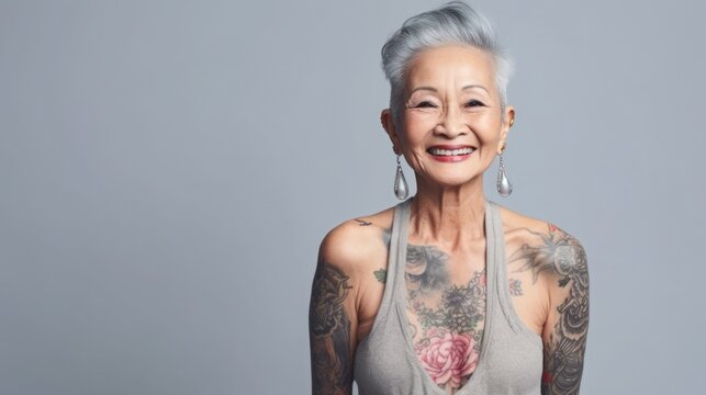 adult asian woman with gray hair and tattoo smiling. drawing on the skin. average age. self-expression and beauty