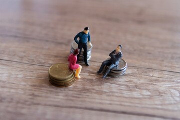 Businessmen figurine and stack of coins. Business meeting, shareholder and funding concept.