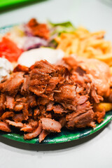 A kebab plate with salad and fries.