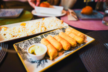 Tequeños and grated cheese on a serving platter.