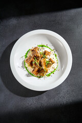 Top view of crispy eggplant with stracciatella cheese and green sauce, a contemporary culinary presentation