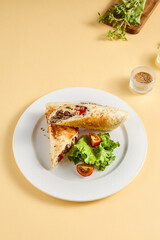 Grilled beef shawarma sandwich on a white plate, garnished with fresh lettuce and tomato. Suitable for fast food advertising and snack bar menus