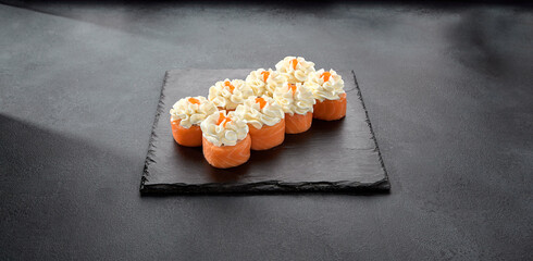 Deluxe Philadelphia rolls wrapped in salmon and topped with a dollop of cream cheese, a luxurious sushi treat