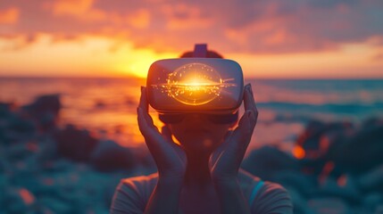 Silhouetted individual experiencing virtual reality with glowing VR glasses against a vibrant sunset over the ocean. - obrazy, fototapety, plakaty