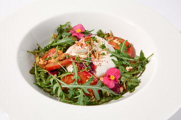 Italian salad with burrata, tomatoes, and arugula, elegantly arranged and garnished with edible flowers