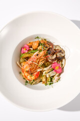 Top View of Zucchini Seafood Sauté with Shrimp and Floral Garnish